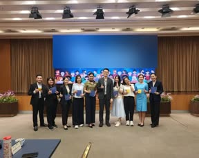 ภาพหมู่ผู้เข้าร่วมอบรมยืนเรียงหน้าจอในห้องประชุมใหญ่