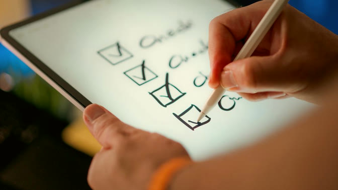 ปากกา stylus กำลังติ๊กรายการใน checklist บนแท็บเล็ต